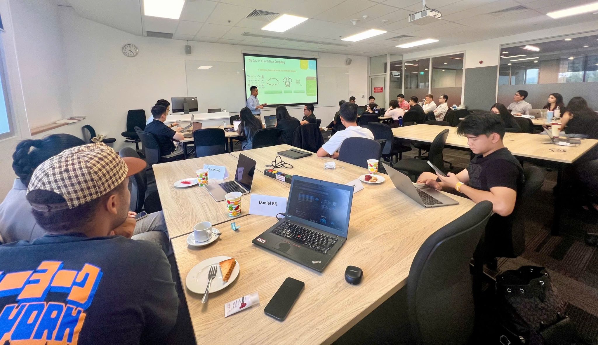 Khoa speaking to an MBA classroom at RMIT Vietnam, with students gathered around tables.